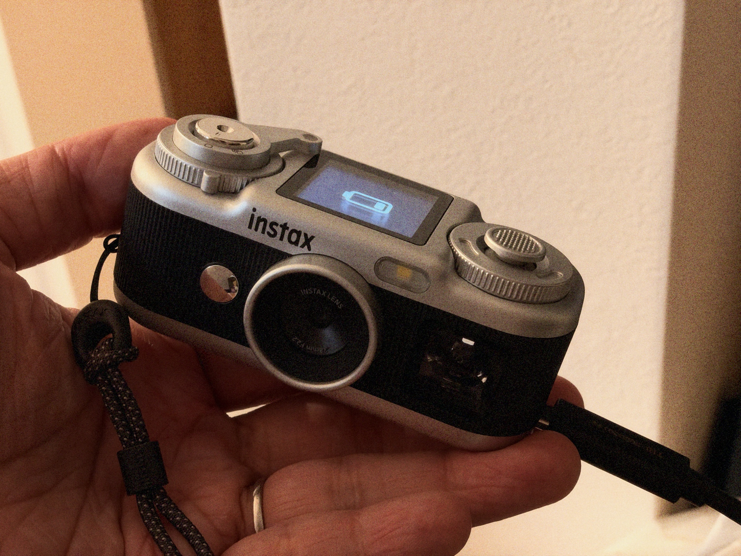 充電中のinstax Pal 2。天面の液晶に電池のマークが出ている